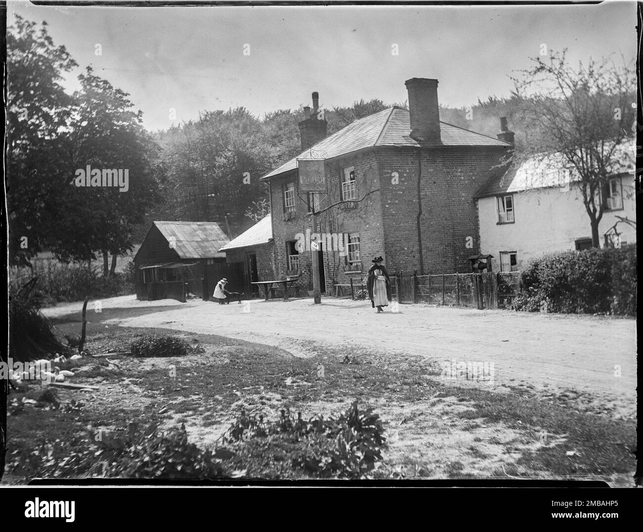 The Plough, Lower Cadsden, Princes Risborough, Wycombe, Buckinghamshire, 1910. A view of The Plough inn from the north, with a woman walking past the pub and a girl and dog outside the entrance. Stock Photo