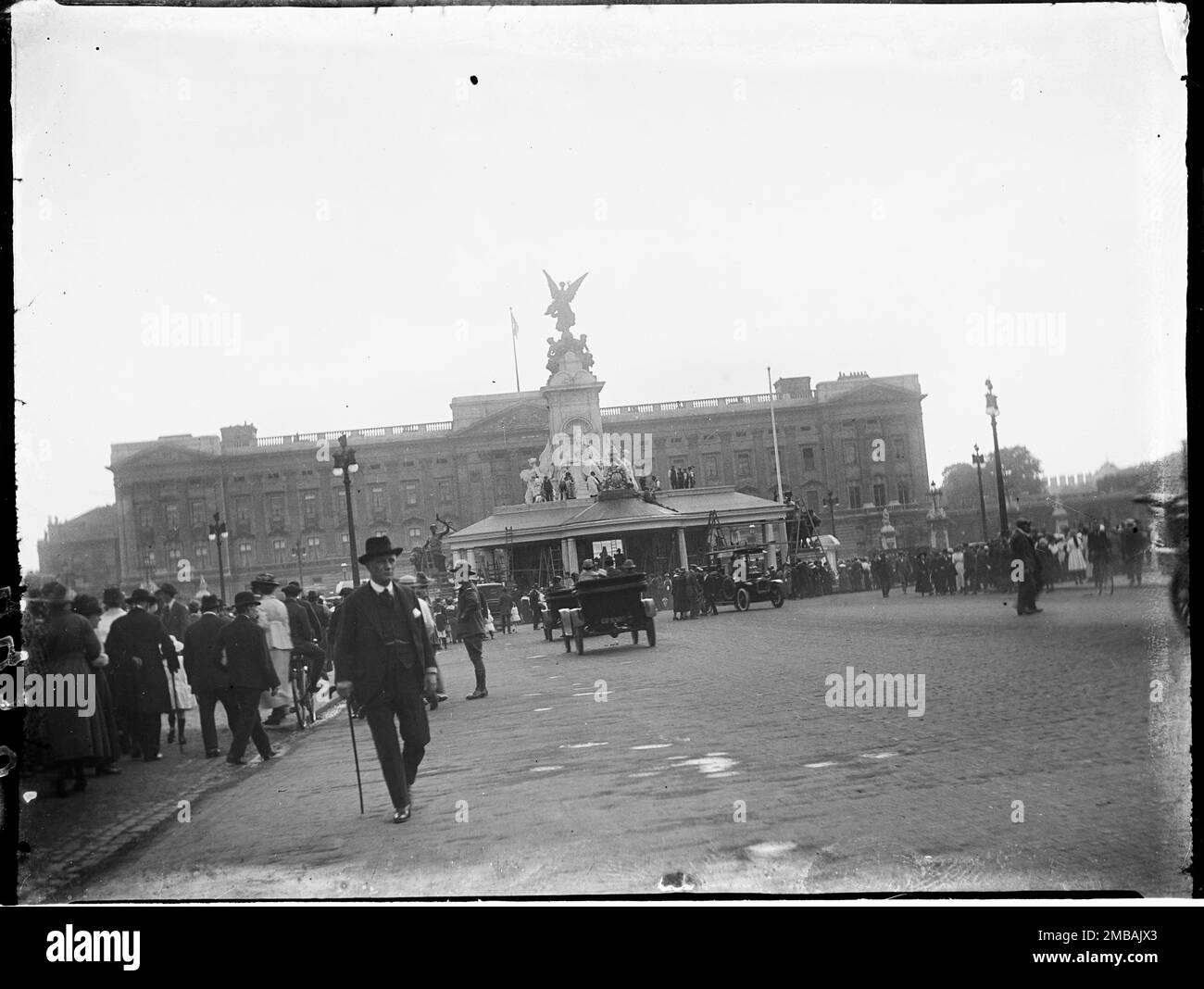 The Mall, City of Westminster, Greater London Authority, 1919. A view of pedestrians and cars on The Mall in front of Buckingham Palace. In the centre is the King's Stand erected around the Queen Victoria Memorial.This photograph is one of a group the photographer took on the 18th, 21st &amp; 23rd July 1919 recording the peace decorations that had been erected in London for Peace Day and the Victory March, 19th July 1919, in celebration of the end of World War 1. Stock Photo