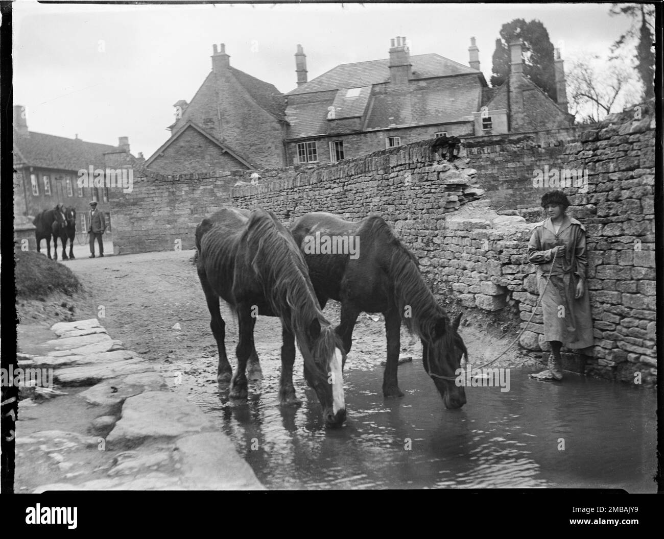 Burford, West Oxfordshire, Oxfordshire, 1924. A woman watching her two
