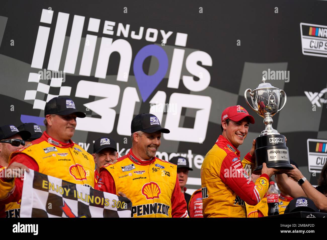 Madison I'll Raceway Joey Logano, right, holds the trophy after winning a NASCAR Cup Series ...