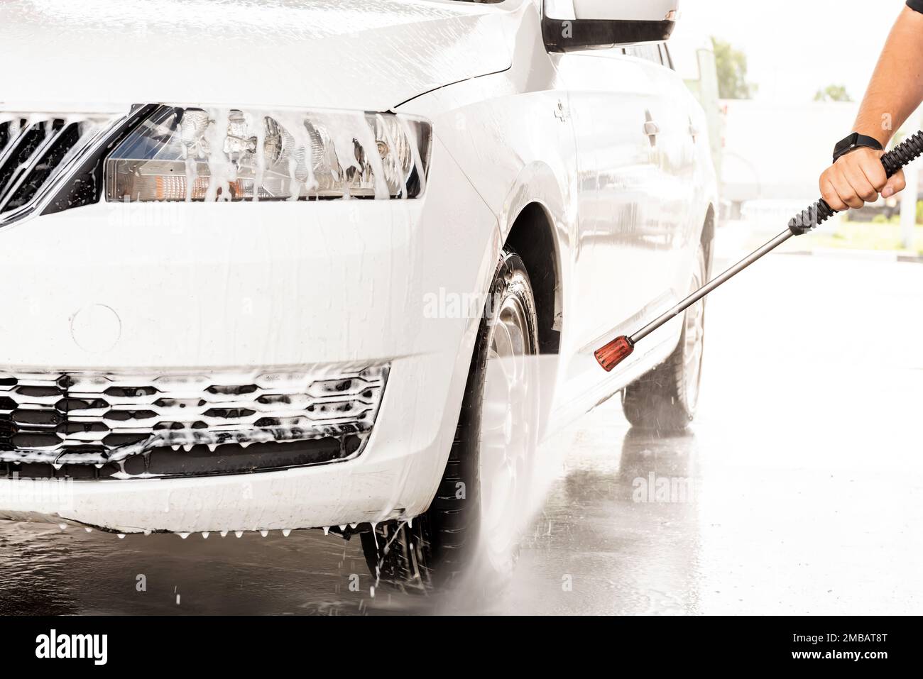 The process of washing a white car at a selfservice car wash Stock
