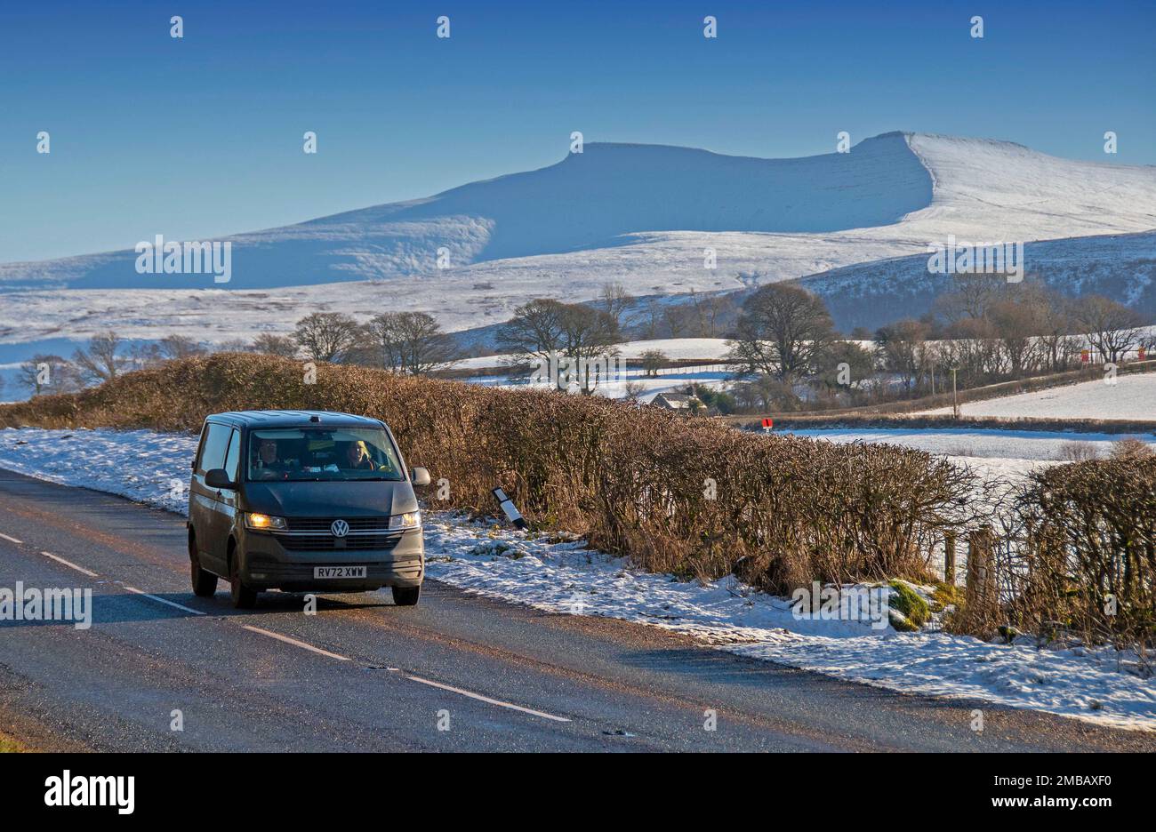 Brecon, UK. 20th Jan, 2023. Cars driving on the road near Libanus on a stunning sunny winters day in the Brecon Beacons National Park which is still covered in snow this afternoon as the freezing weather continues. Credit: Phil Rees/Alamy Live News Stock Photo