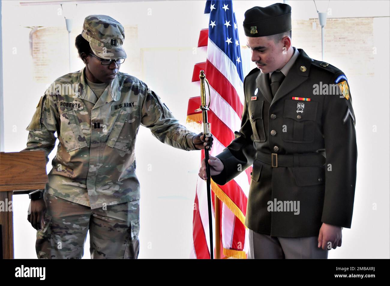 Left, U.S. Army Cpt. Winstina E. Roberts, 529th MP Company, gives the sword to Pv2 Robert Torres