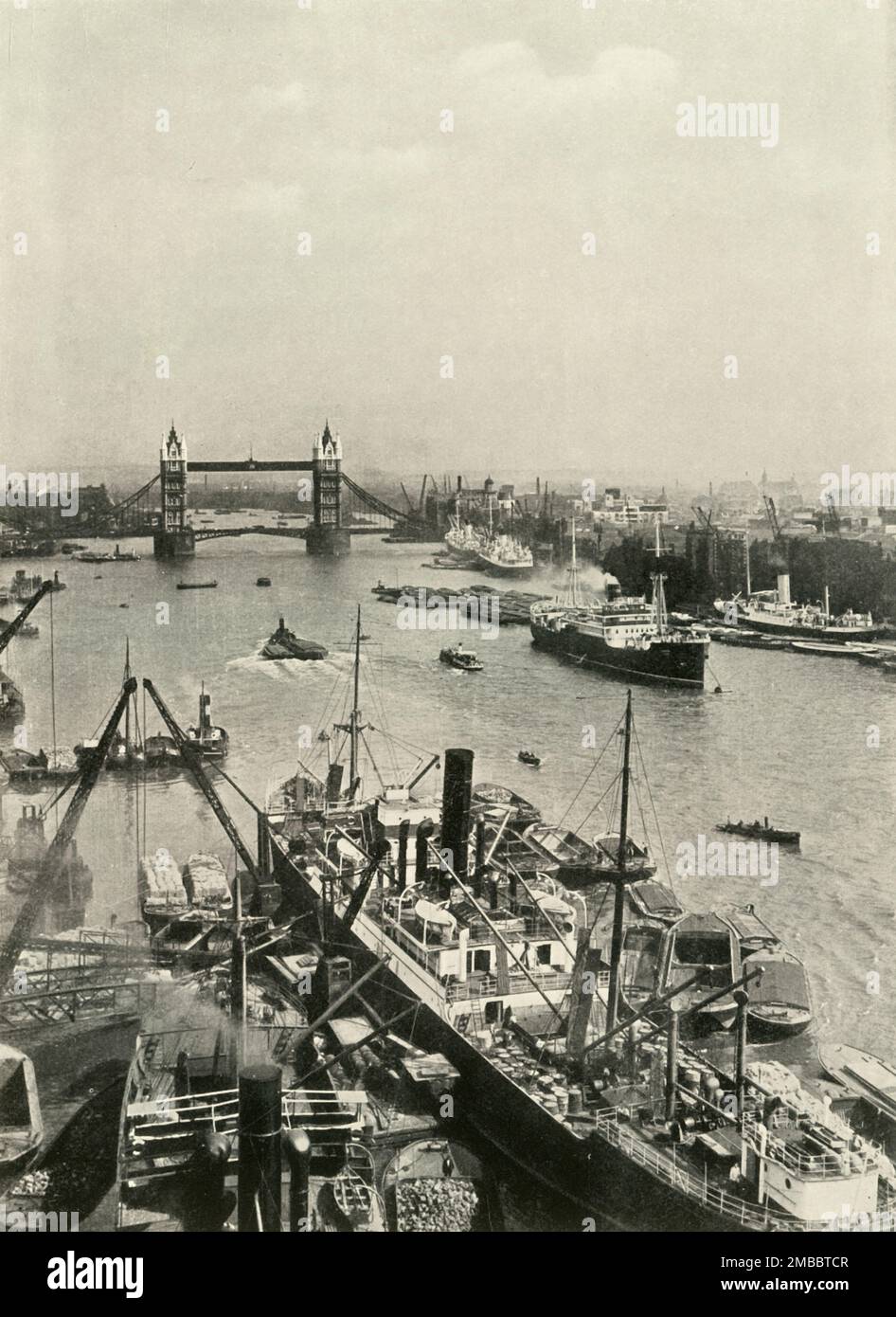 &quot;But The Prospect in the Neighbouring Pool - The More It Changes, The More It Is The Same&quot;', 1937. Cargo ships in the Pool of London, River Thames. In the distance is Tower Bridge. From &quot;The Said Noble River&quot;, by Alan Bell. [The Port of London Authority, London, 1937] Stock Photo