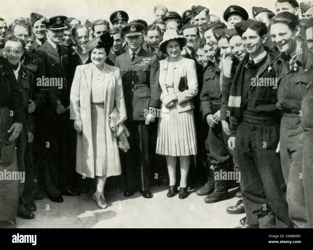 'At a Bomber Command Station', 5 July 1944, (1947). King George VI and Queen Elizabeth with daughter Princess Elizabeth (future Queen Elizabeth II) visiting a British bomber station during the Second World War. They met crews who had just returned from an attack on enemy flying bomb bases in France. From &quot;Princess Elizabeth: The Illustrated Story of Twenty-one Years in the Life of the Heir Presumptive&quot;, by Dermot Morrah. [Odhams Press Limited, London, 1947] Stock Photo