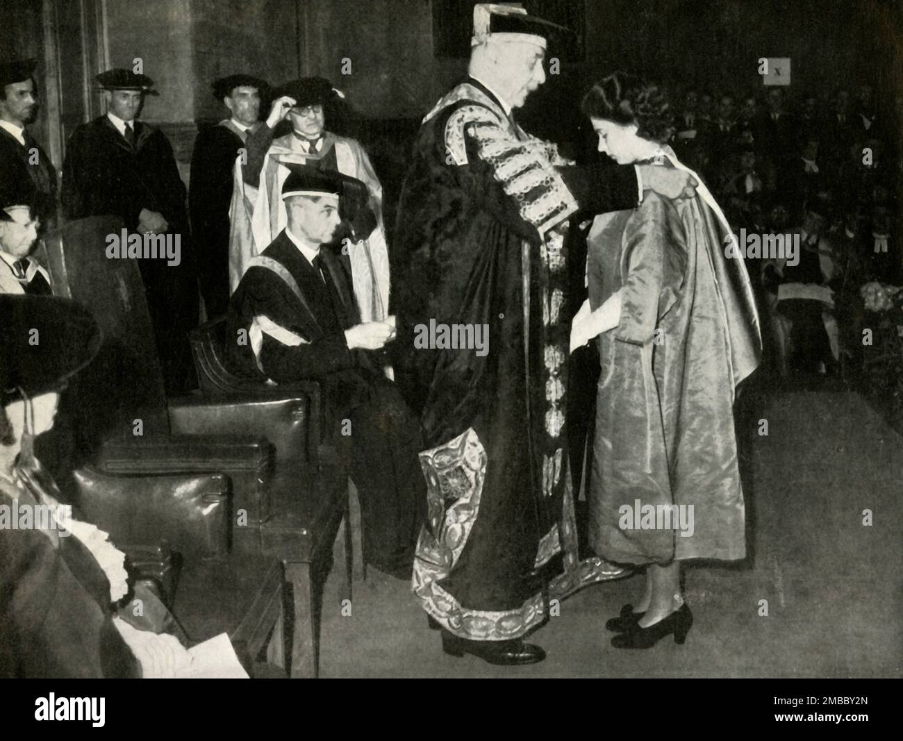 Bachelor of Music', 10 July 1946, (1947). Princess Elizabeth (future Queen Elizabeth II) receives the honorary degree of Bachelor of Music at the London University. 'The Chancellor, the Earl of Athlone, admits his great-niece to the degree'. From &quot;Princess Elizabeth: The Illustrated Story of Twenty-one Years in the Life of the Heir Presumptive&quot;, by Dermot Morrah. [Odhams Press Limited, London, 1947] Stock Photo