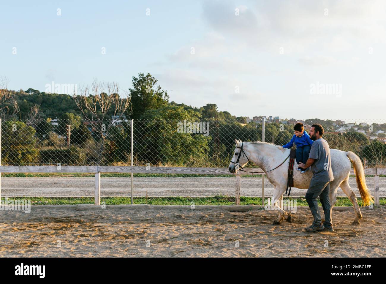 Child during an equine therapy session outdoors Stock Photo