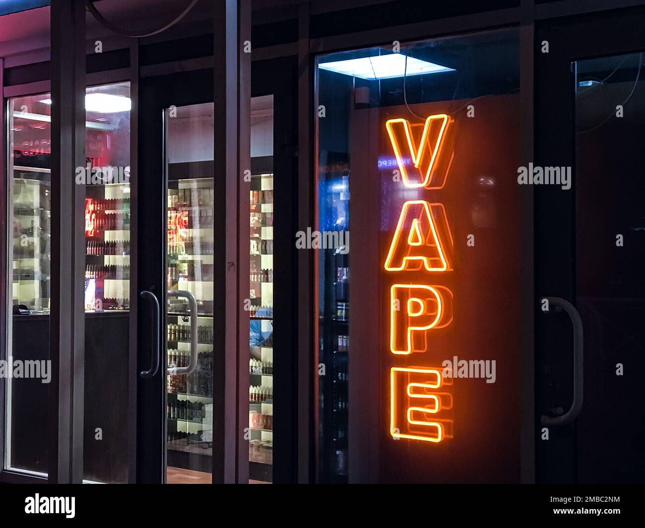 vape shop electronic cigarette neon colored window showcase sign lights glow  up attracting customers on the street at night.concept vape shop Stock  Photo