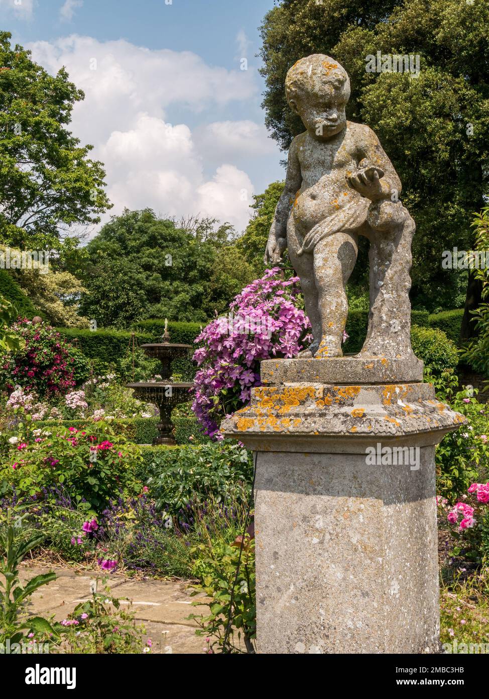 Ornamental stone cherub statue in the Rose garden at Belvoir Castle,  Leicestershire, England, UK Stock Photo