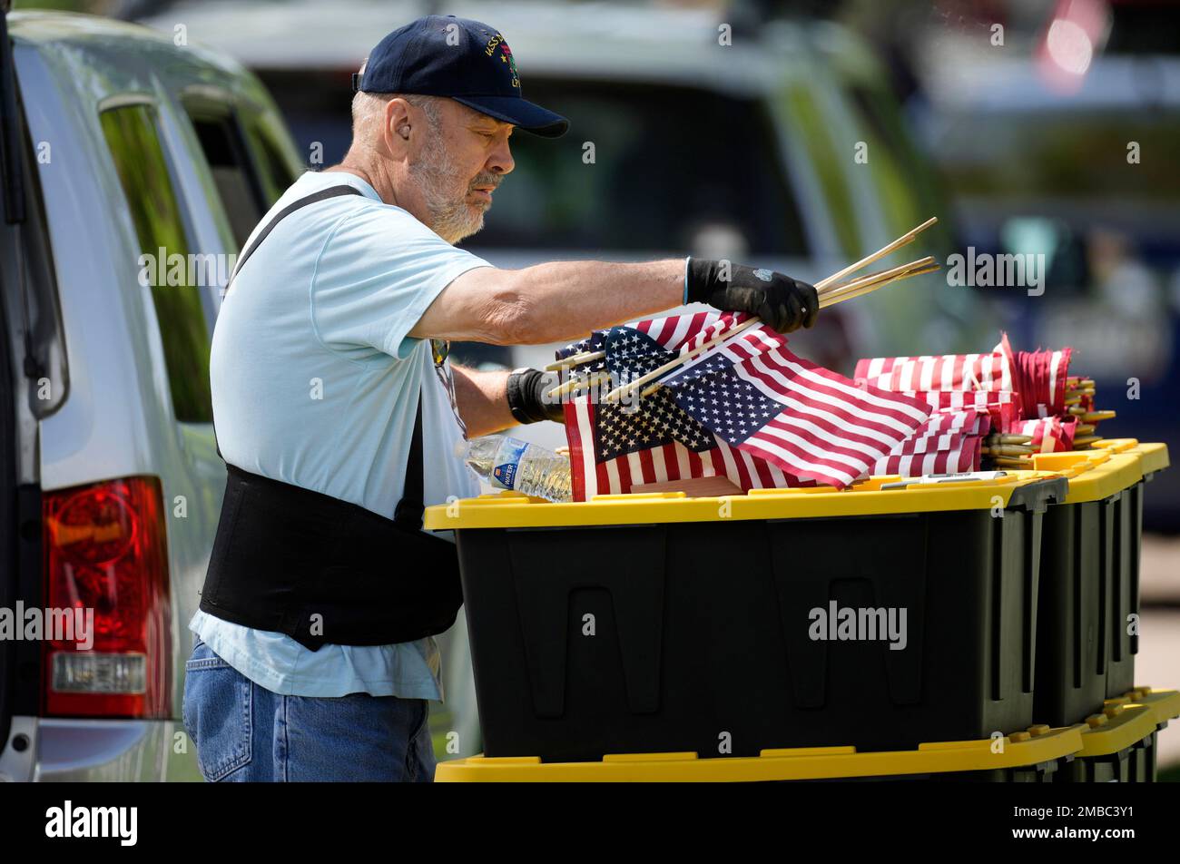 Robert Petrie, of Denver, prepares bundles of American flags for