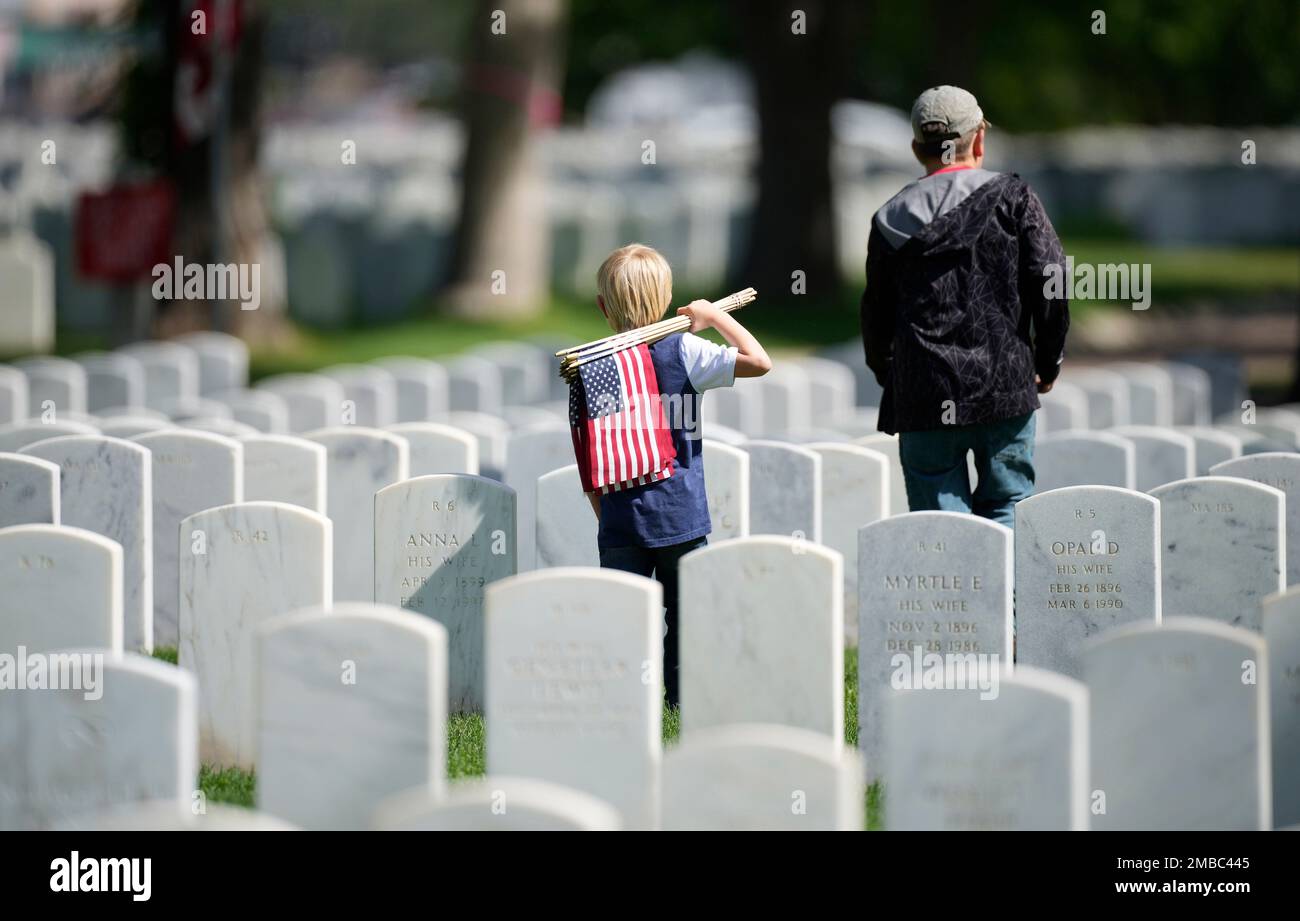 A pair of young volunteers head out to place flags at headstones in