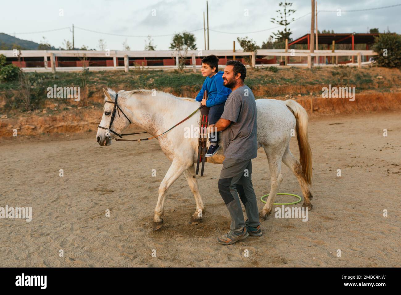 boy with disability riding a horse during a session of physiotherapy Stock Photo