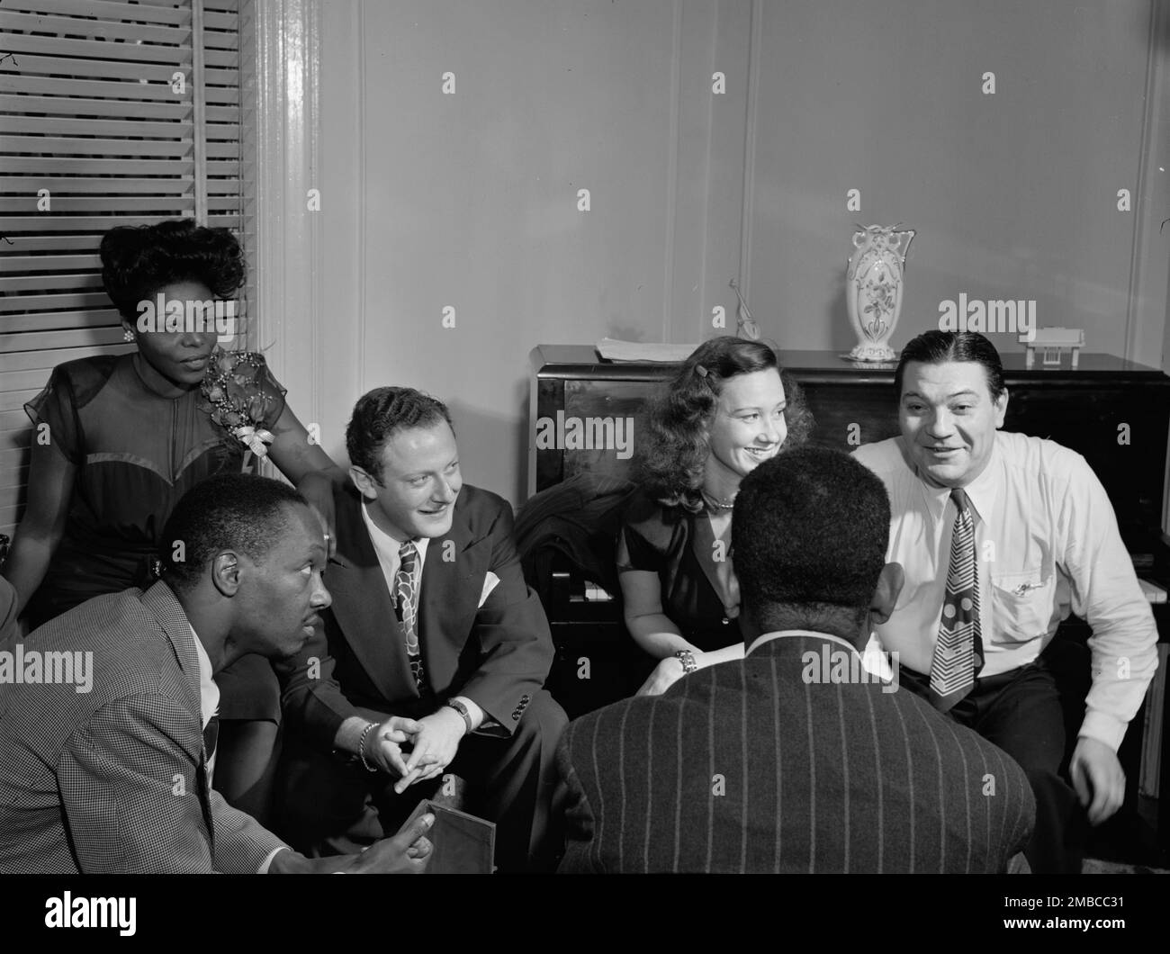 Portrait of Tadd Dameron, Mary Lou Williams, Milt Orent, Dixie Bailey, Jack Teagarden, and Dizzy Gillespie, Mary Lou Williams' apartment, New York, N.Y., ca. Aug. 1947. Stock Photo