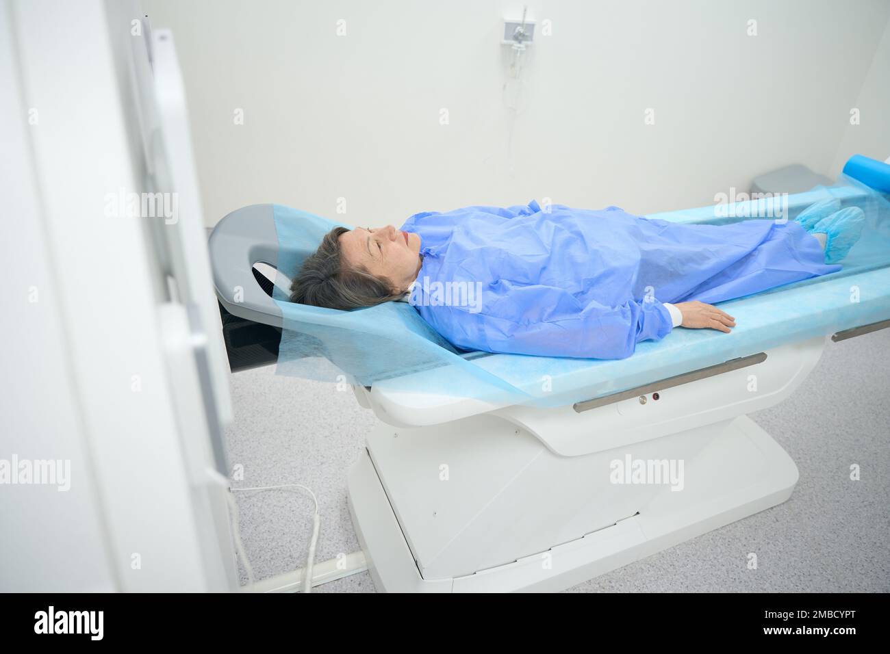 Patient in special clothes lies on mobile surface of MRI machine Stock