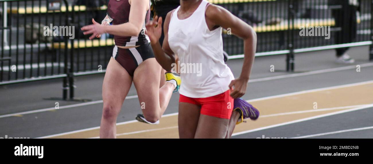 Two high school girls track runners sprinting to the finish line in