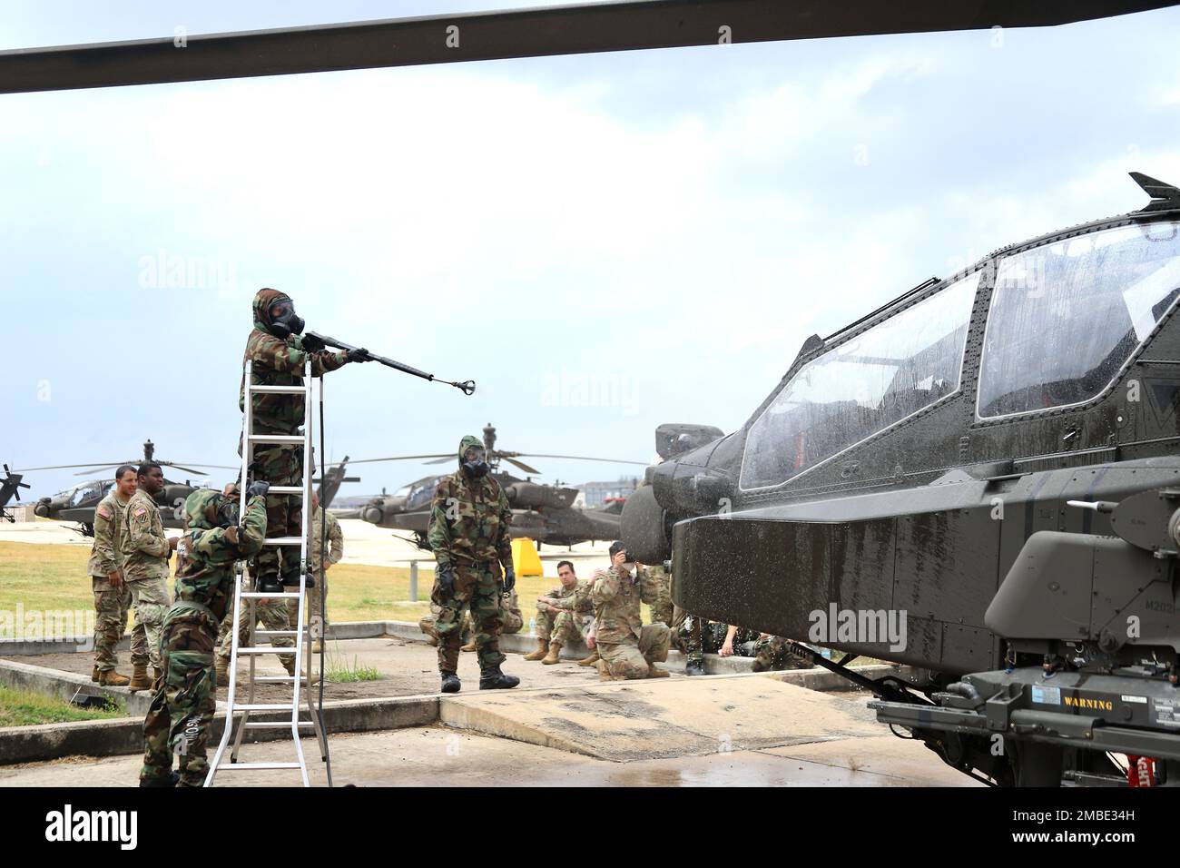 Soldiers from 23rd Chemical Battalion, 2nd Infantry Division Sustainment Brigade lead a class on decontamination of an AH-64E v6 Apache helicopter. The Soldiers from 4-2 Attack Battalion, 2nd Combat Aviation Brigade were able to get a hands on experience of using the M26 decontamination apparatus to spray down the helicopter. Stock Photo