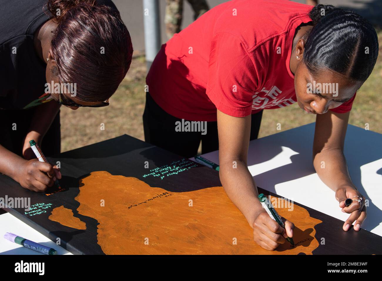 Participants conclude the African American Heritage Council’s Walk In Their Shoes event by signing a Juneteenth memorial poster at Spangdahlem Air Base, Germany, June 15, 2022. The AAHC promotes diversity and inclusion around Spangdahlem by hosting events and discussions designed to start meaningful conversations on diversity. Stock Photo