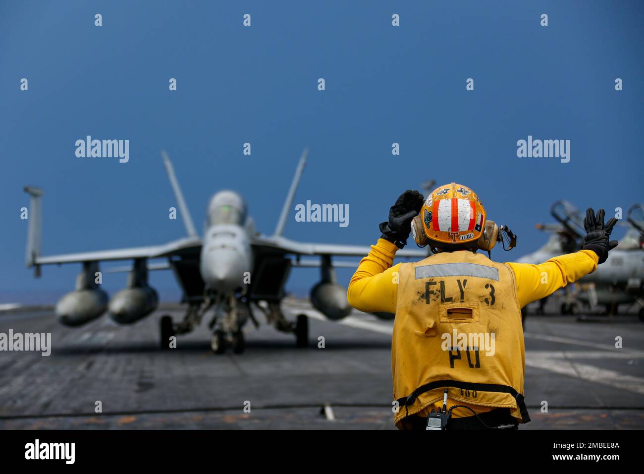 PHILIPPINE SEA (June 15, 2022) Aviation Boatswain's Mate (Handling) 1st Class Daniel Suggs, from Killeen, Texas, directs an F/A-18F Super Hornet, assigned to the 'Black Aces' of Strike Fighter Squadron (VFA) 41, on the flight deck of the Nimitz-class aircraft carrier USS Abraham Lincoln (CVN 72). Abraham Lincoln Strike Group is on a scheduled deployment in the U.S. 7th Fleet area of operations to enhance interoperability through alliances and partnerships while serving as a ready-response force in support of a free and open Indo-Pacific region. Stock Photo