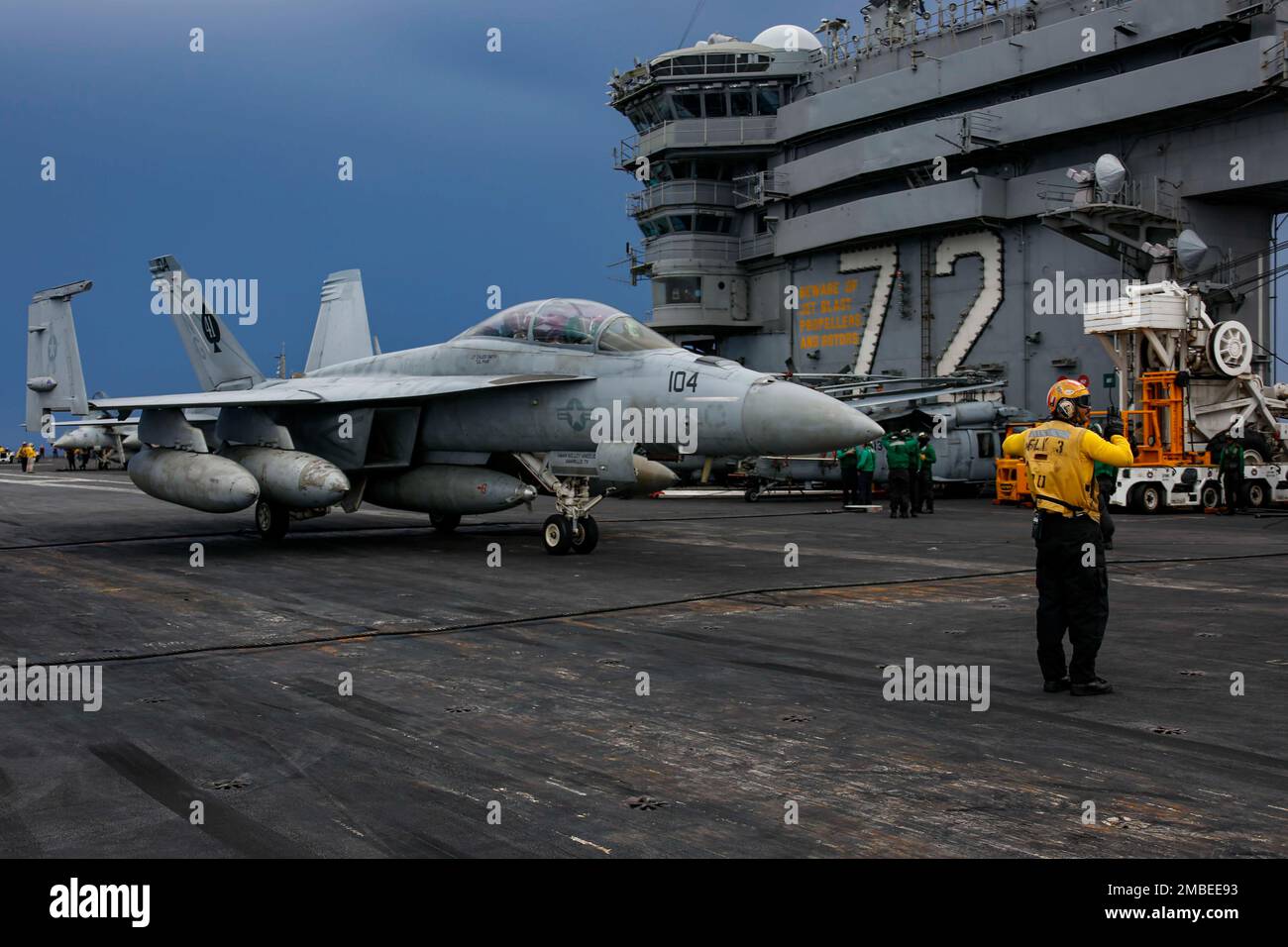 PHILIPPINE SEA (June 15, 2022) Aviation Boatswain's Mate (Handling) 1st Class Daniel Suggs, from Killeen, Texas, directs an F/A-18F Super Hornet, assigned to the 'Black Aces' of Strike Fighter Squadron (VFA) 41, on the flight deck of the Nimitz-class aircraft carrier USS Abraham Lincoln (CVN 72). Abraham Lincoln Strike Group is on a scheduled deployment in the U.S. 7th Fleet area of operations to enhance interoperability through alliances and partnerships while serving as a ready-response force in support of a free and open Indo-Pacific region. Stock Photo