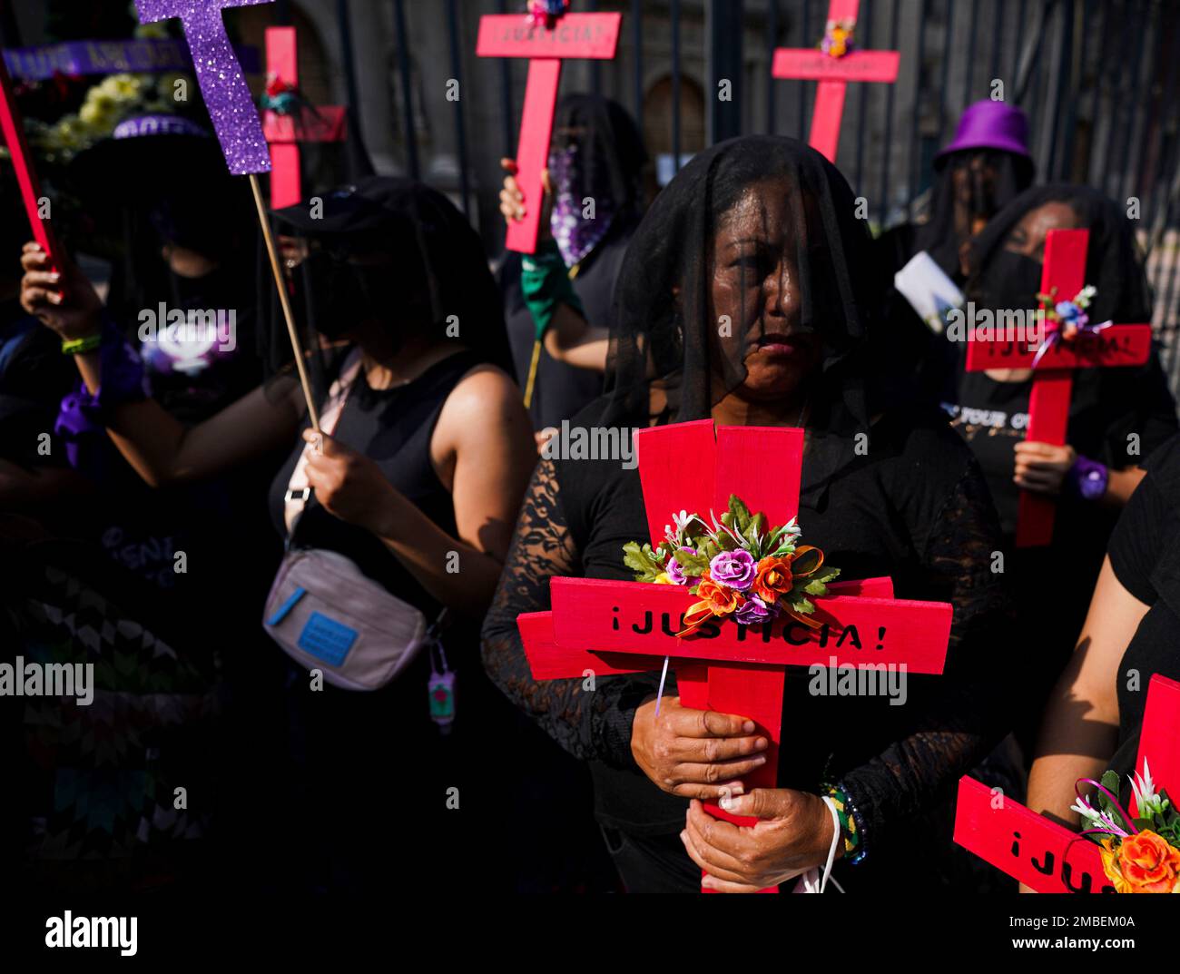 Demonstrators in black veils holds crosses with a Spanish word "Justice ...