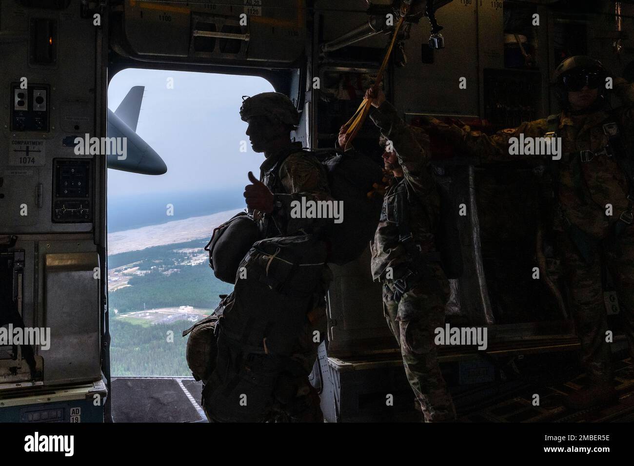 U.S. Army Sgt. 1st Class Charlie Arrendale, gives a thumbs-up signal prior to the paratroopers jumping out of a C-17 Globemaster III from the 517th Airlift Squadron, Joint Base Elmendorf-Richardson, Alaska over Allen Army Airfield, Fort Greely, June 15, 2022. RF-A provides realistic combat training by integrating joint, coalition and multilateral forces into simulated forward operating bases. The paratroopers and Arrendale are assigned to the 2nd Infantry Brigade Combat Team (Airborne), 11th Airborne Division. Stock Photo