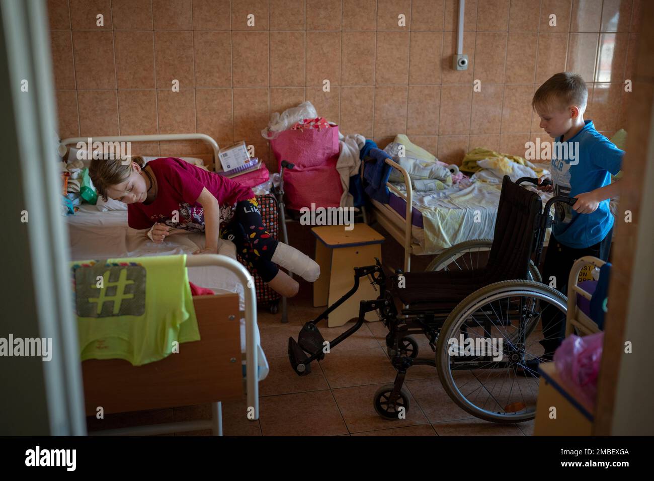 Yana Stepanenko, 11, is assisted by her twin brother Yarik, at a