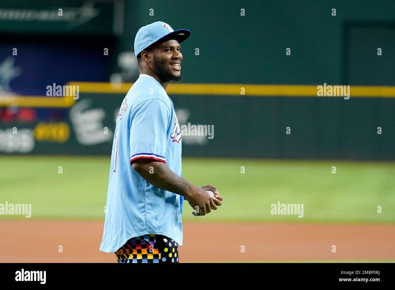 Dallas Cowboys player Micah Parsons walks to the mound to throw out the  ceremonial first pitch before a baseball game between the Los Angeles  Angels and the Texas Rangers, Tuesday, May 17,