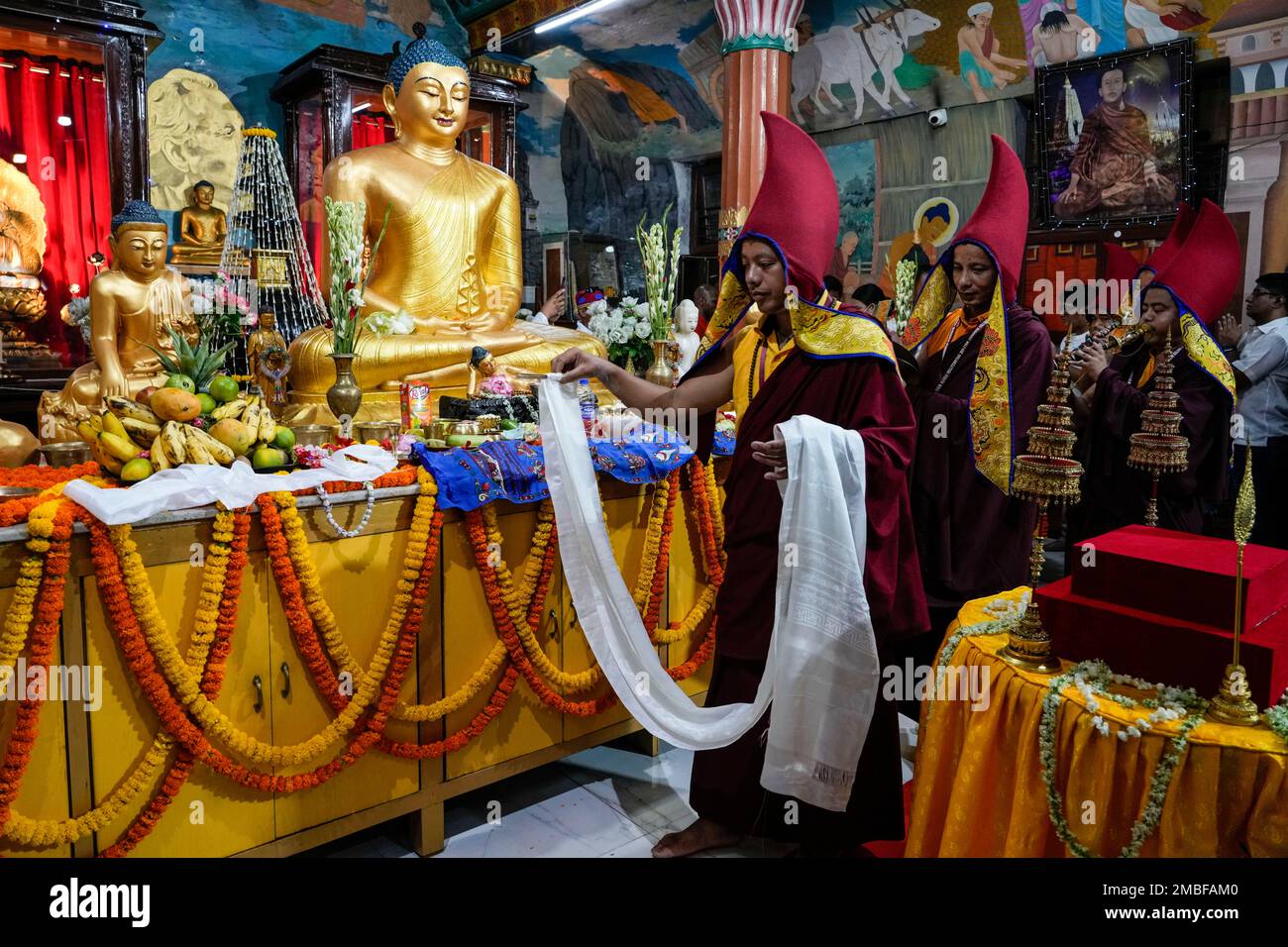 Buddhist monks enter a temple in a procession to offer prayers in front
