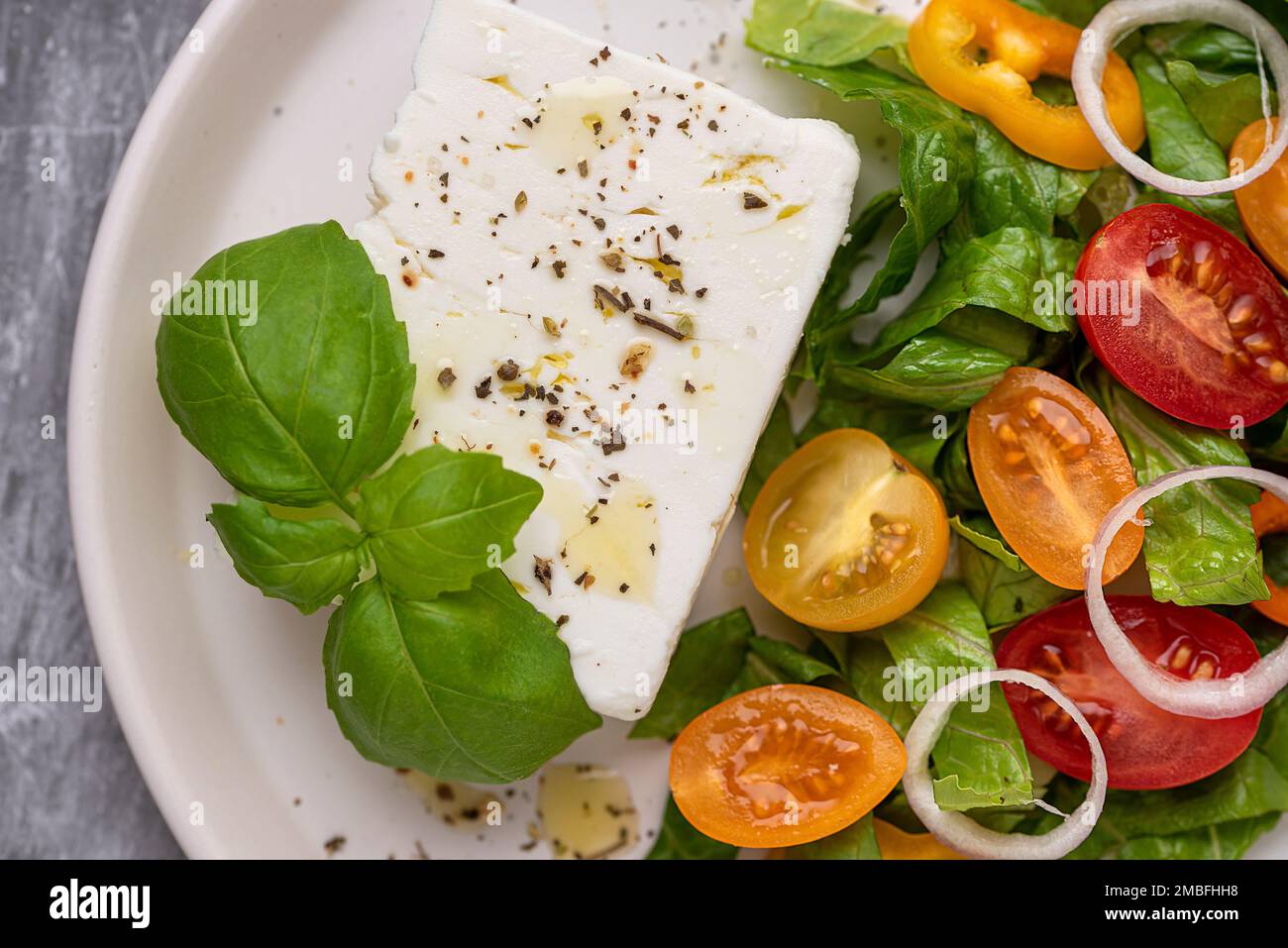 Macro food photography of feta salad, vegetable, tomato, cucumber, onion, lettuce, romaine, sauce, bell pepper Stock Photo