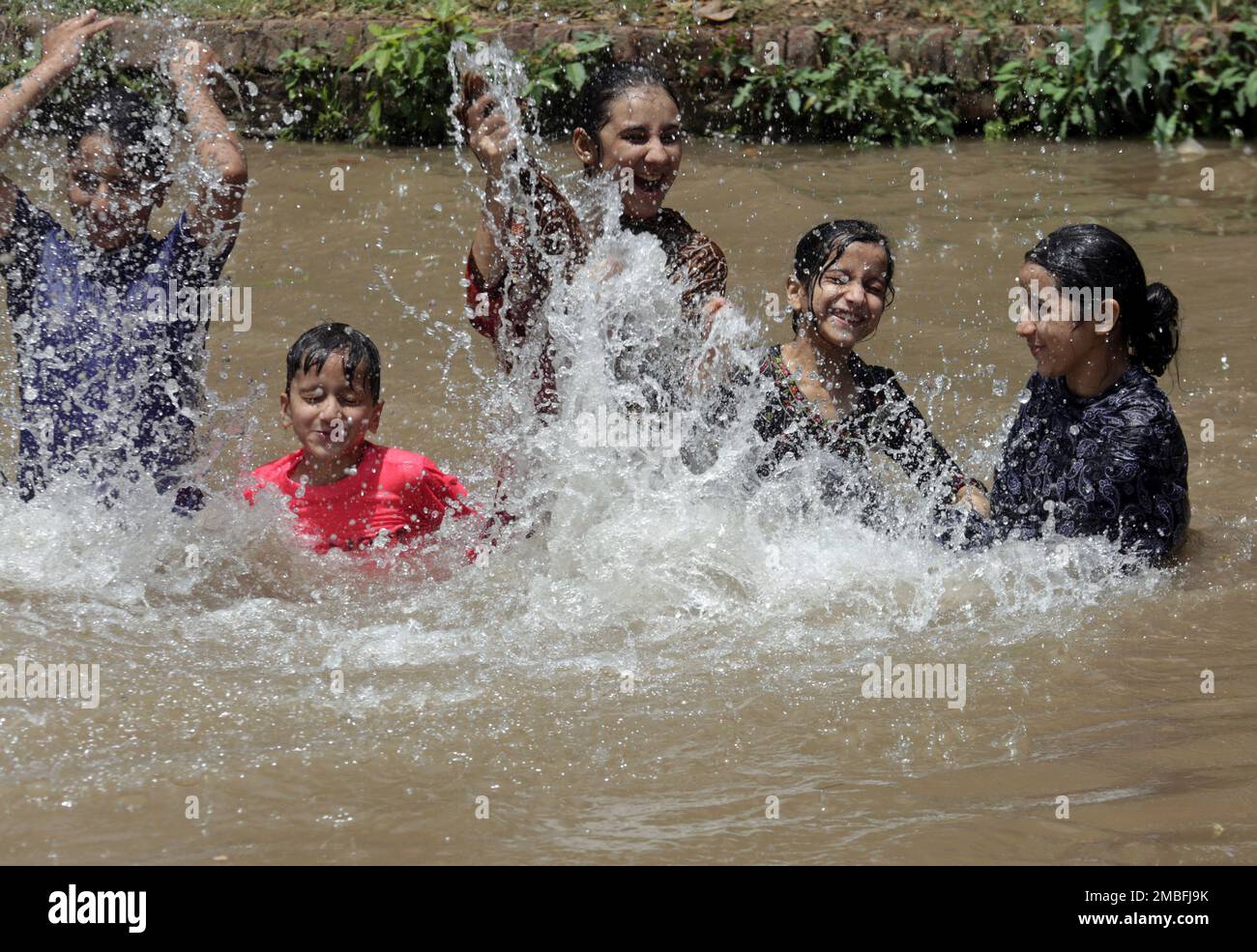 Children swim in a canal to cool off as temperature reached 44 C