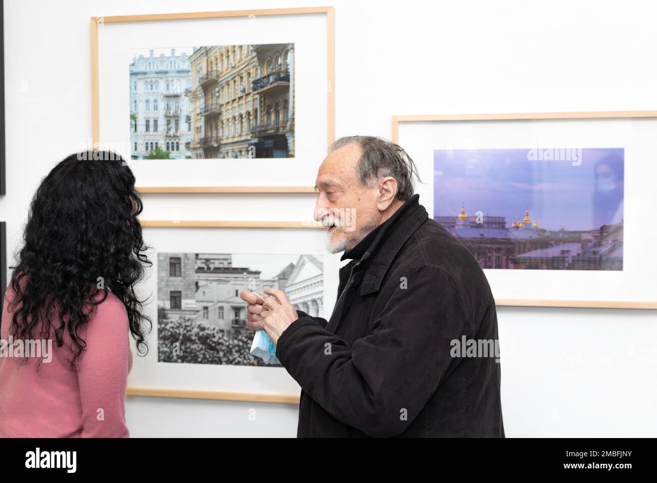 Photo exhibition Kyiv Emerging in Kommunale Galerie Berlin, Germany. Ukrainian photographer Boris Mikhailov speaking with one of the participants. Stock Photo