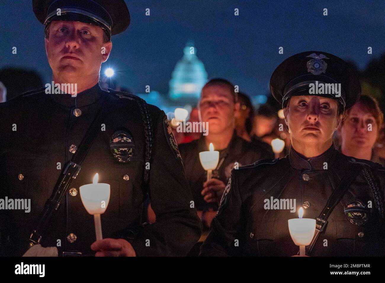 Law enforcement personnel hold candles during the 34th Annual