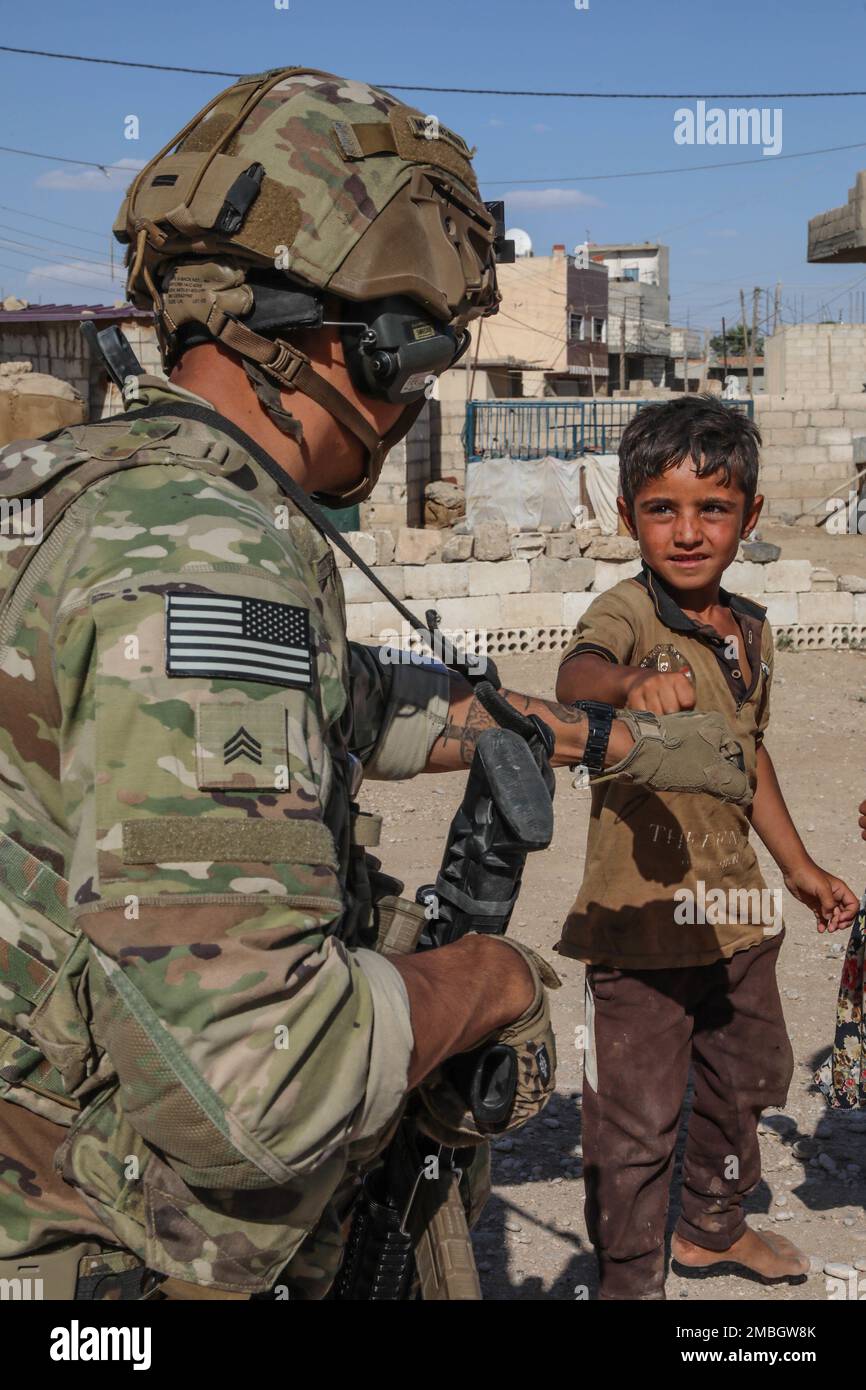 U.S. Soldier assigned to Attack Company 1/32 Infantry, 1st Brigade, 10th Mountain Division engage with the local populace in Syria on June. 15, 2022. Combined Joint Task Force - Operation Inherent Resolve continues to advise, assist, and enable partner forces in designated areas of Syria to set conditions for long-term security. Stock Photo