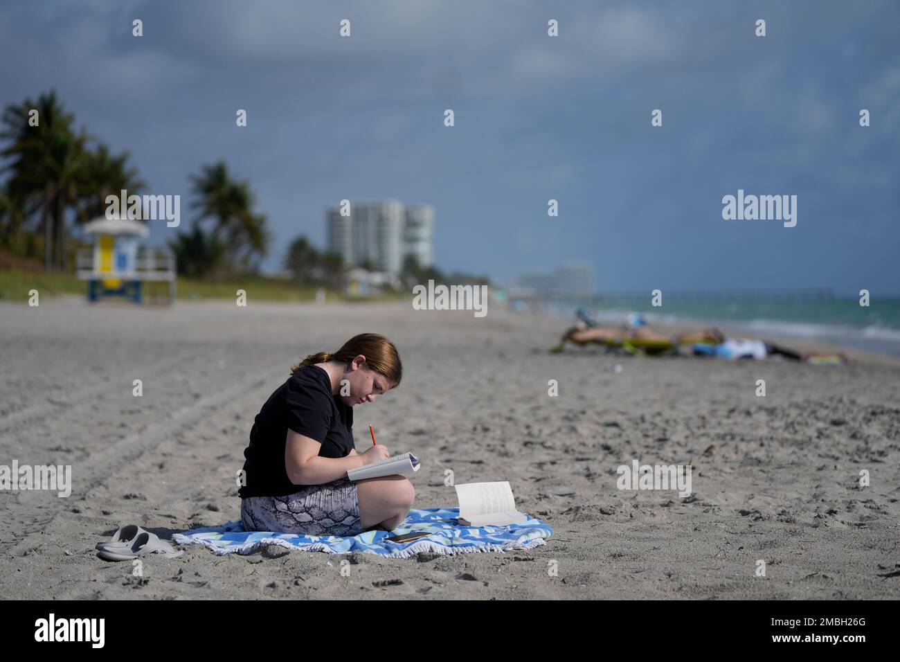 Eden Hebron, 19, writes in her journal on the beach near her parent's