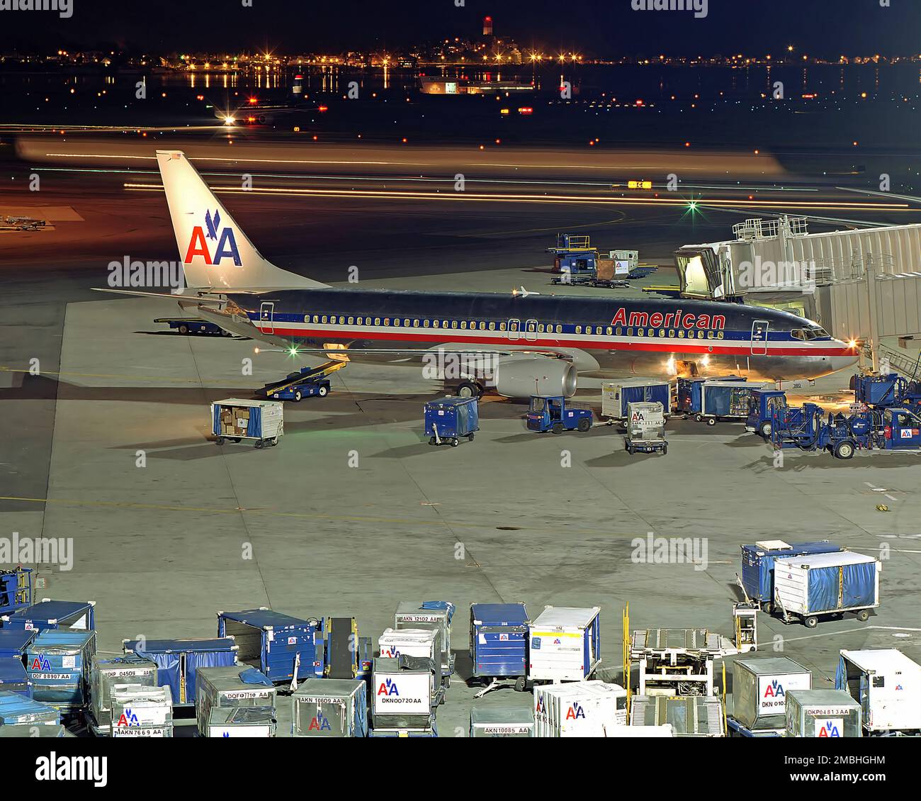 American Airlines 737 plane prepares for departure with baggage cart handlers, vintage night photo Stock Photo