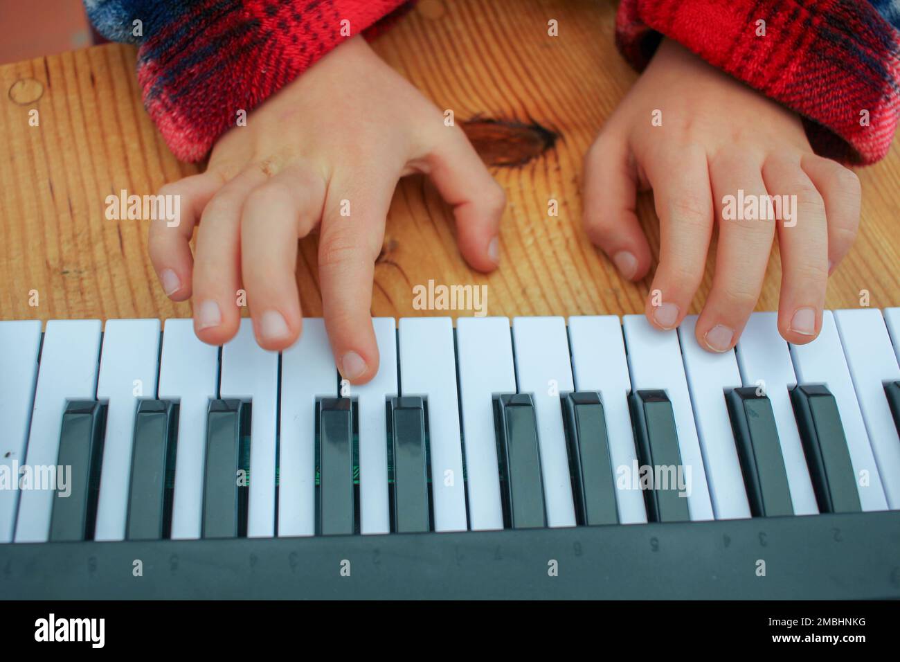 learning to play piano at home in a toy keyboard Stock Photo Alamy