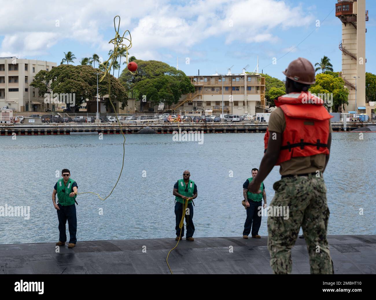 220616-N-LN285-3054 JOINT BASE PEARL HARBOR-HICKAM (June 16, 2022) -- Sailors aboard the Los Angeles-class fast-attack submarine USS Topeka (SSN 754) throw a heaving line to Sailors assigned to Los Angeles-class fast-attack submarine USS Charlotte (SSN 766), June 16, 2022. Topeka is capable of supporting various missions, including anti-submarine warfare, anti-surface ship warfare, strike warfare, and intelligence, surveillance, and reconnaissance. Stock Photo