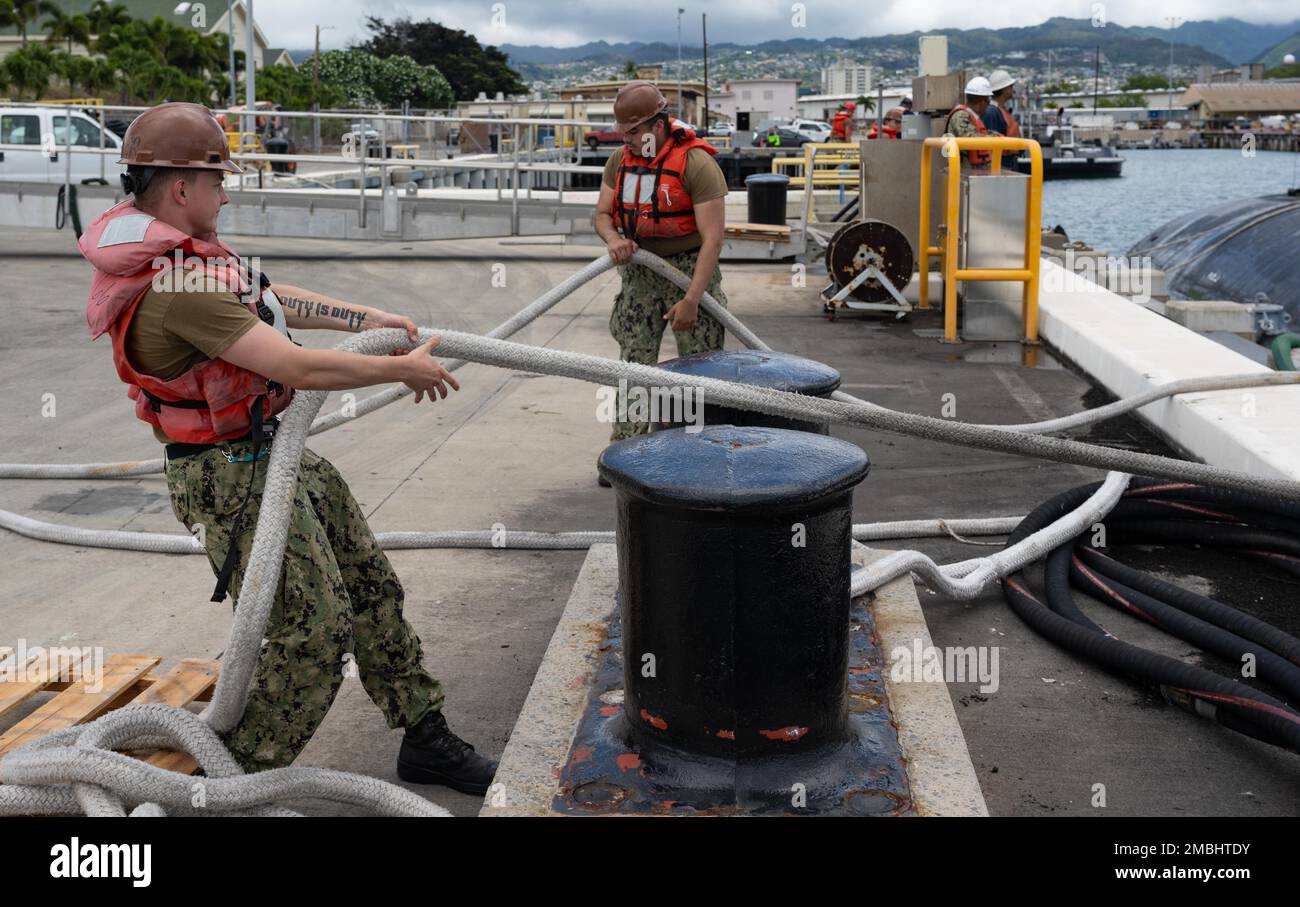 220616-N-LN285-3077 JOINT BASE PEARL HARBOR-HICKAM (June 16, 2022) -- Fire Control Technician Seaman Joseph Pryor, left, from Grass Valley, Ca., and Fire Control Technician Seaman Apprentice Adrian Gongora, right, from Houston, both assigned to the Los Angeles-class fast-attack submarine USS Charlotte (SSN 766), heave a mooring line attached to the Los Angeles-class fast-attack submarine USS Topeka (SSN 754), June 16, 2022. Topeka is capable of supporting various missions, including anti-submarine warfare, anti-surface ship warfare, strike warfare, and intelligence, surveillance, and reconnais Stock Photo