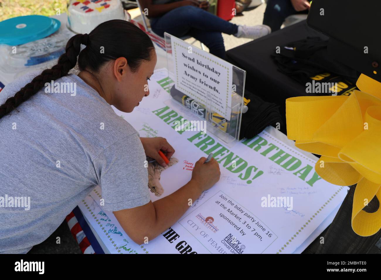 Natalie Dean, a member of the Hinesville community, signs a birthday card for the United States Army at the Hinesville Downtown Farmers Market as part of the local celebration of the Army's birthday in Hinesville, Georgia, June 16, 2022. The U.S. Army celebrates 247 years of 24/7 global readiness and the service of the people who make that capability possible. Stock Photo