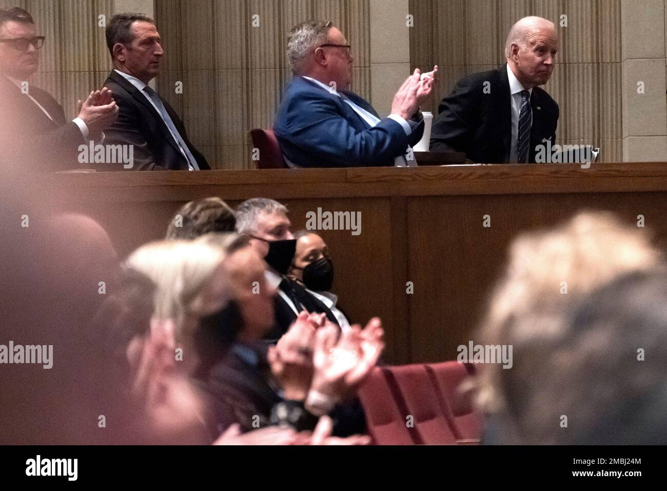 President Joe Biden, right, is applauded before speaking at the the memorial service for former