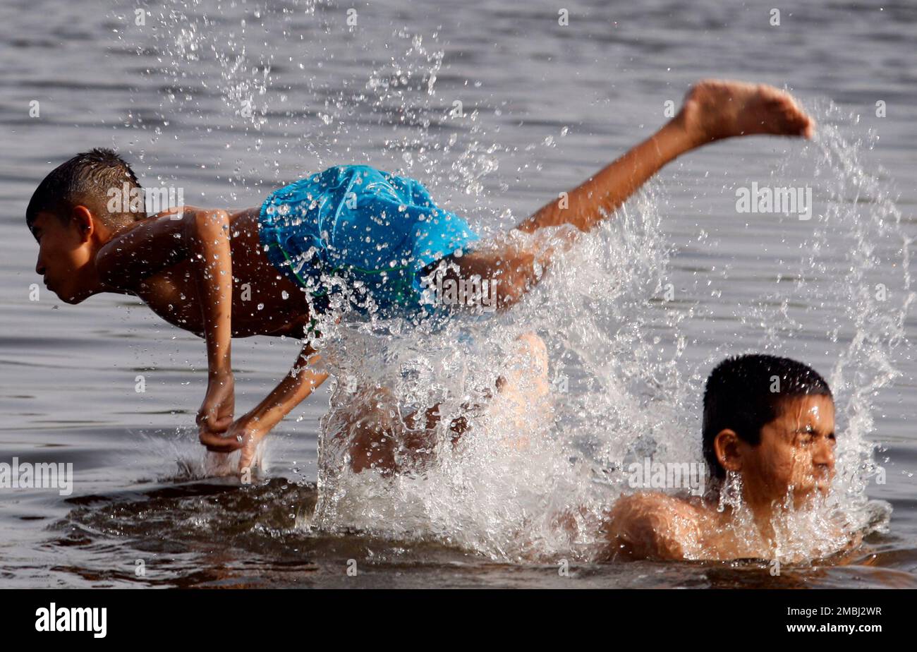 Boys swim in a stream to cool off in Lahore, Pakistan, Sunday, May 1 ...