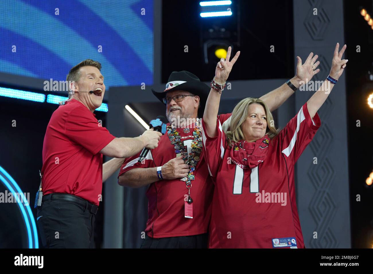 Scott Hanson, left, awards two Arizona Cardinals season ticket members with  tickets to next years Super