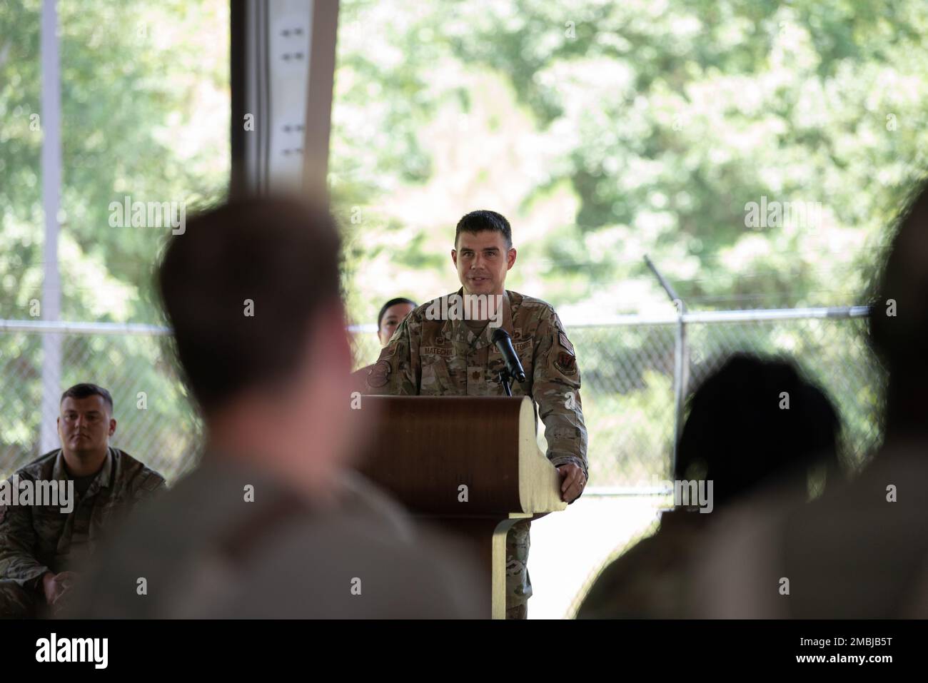 U.S. Air Force Maj. Thomas Matechik, 23rd Security Forces Squadron commander, gives a speech during military working dog TToby’s retirement at Moody Air Force Base, Georgia, June 16, 2022. Matechik spoke of the several operations TToby completed during his time in service. TToby served in four deployments conducting explosive detonation support and secret service missions. Stock Photo