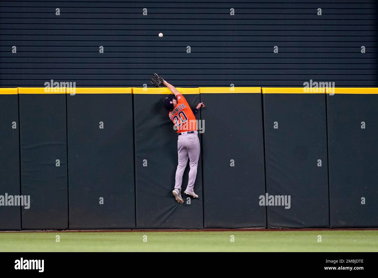Houston Astros right fielder Chas McCormick leaps attempting to reach a