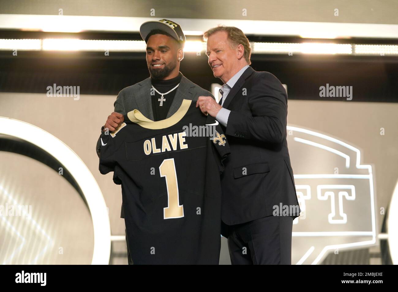 Ohio State wide receiver Chris Olave, left, and Roger Goodell, Commissioner  of the NFL, hold a team jersey after Chris Olave was chosen by the Atlanta  Falcons with the 8th pick at