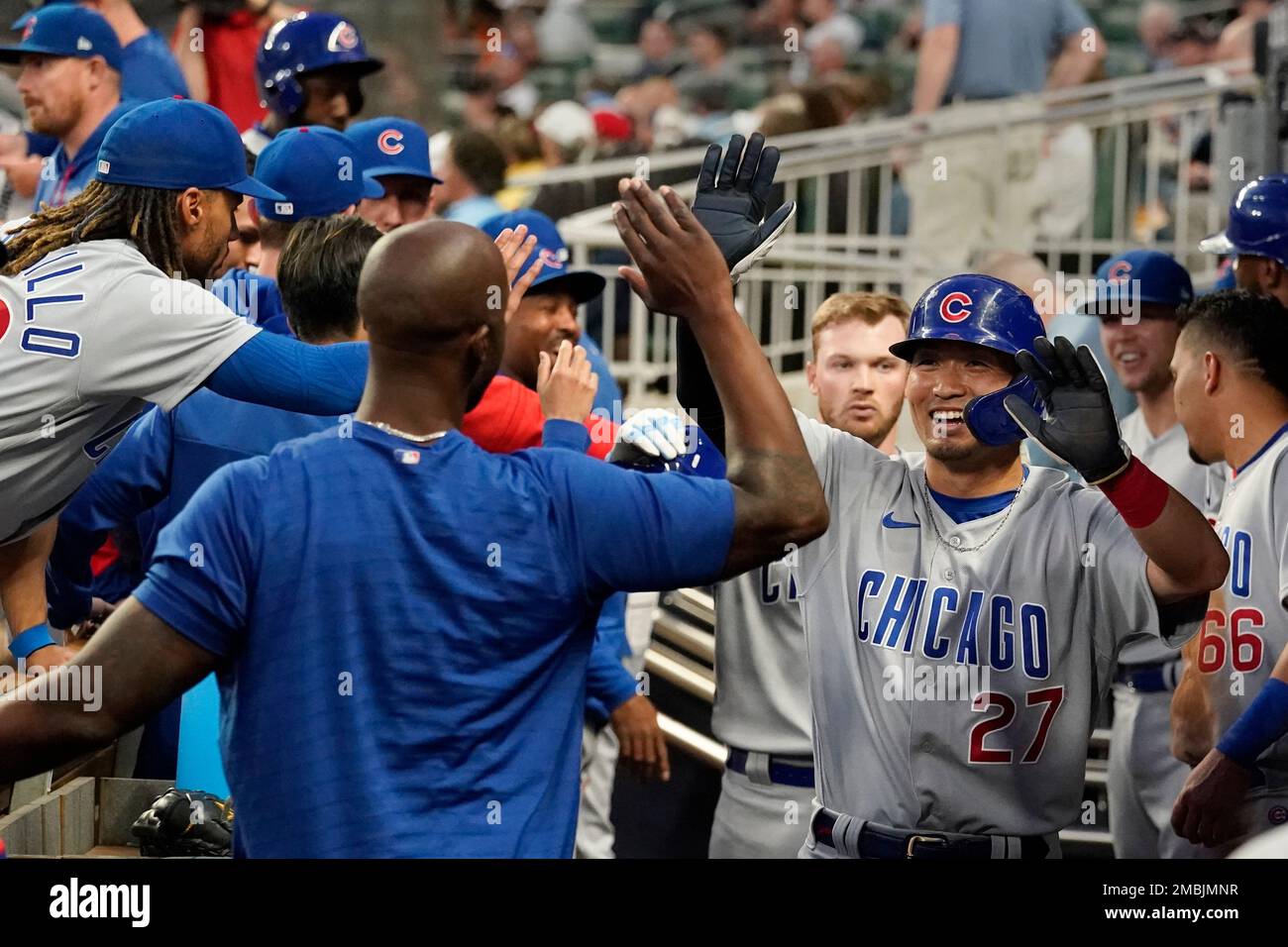 Chicago Cubs' Seiya Suzuki, left, is congratulated by first base coach Mike  Napoli after hitting a single against the San Francisco Giants during the  eighth inning of a baseball game in San