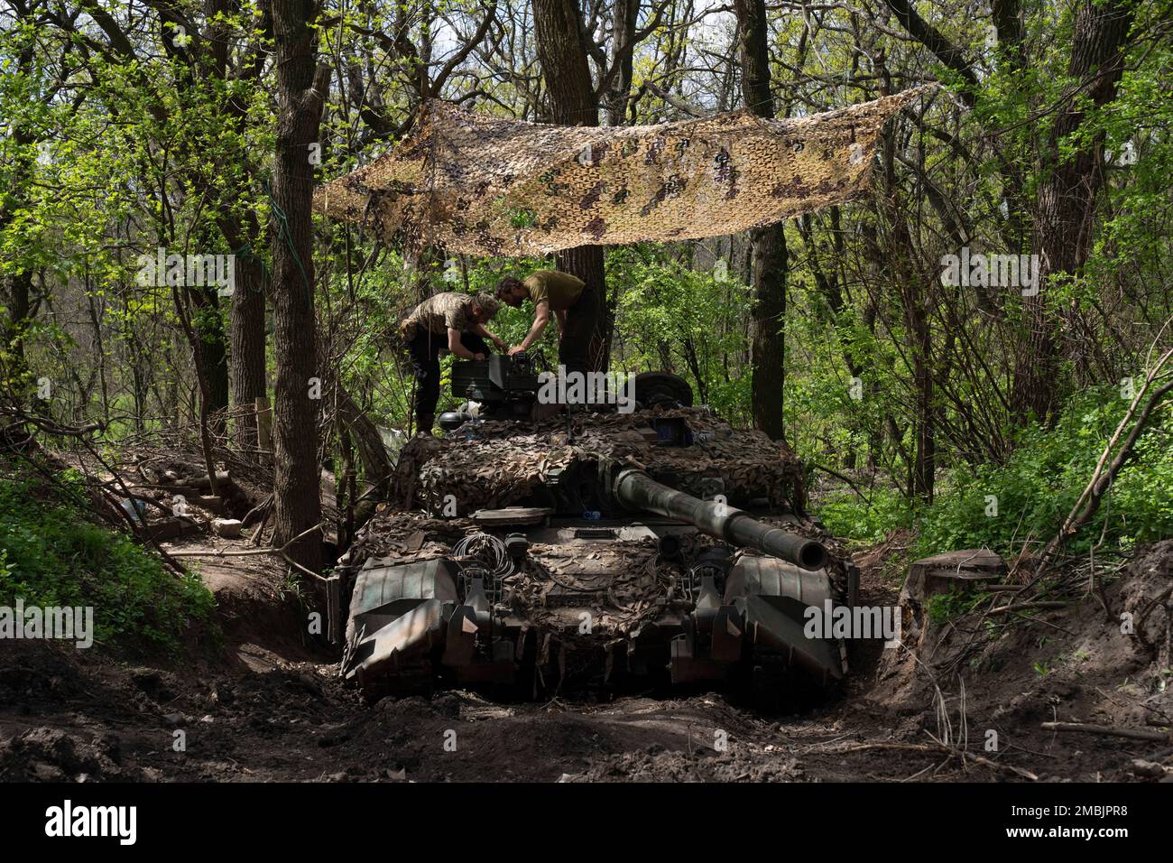 Ukrainian servicemen install a machine gun on the tank during the ...