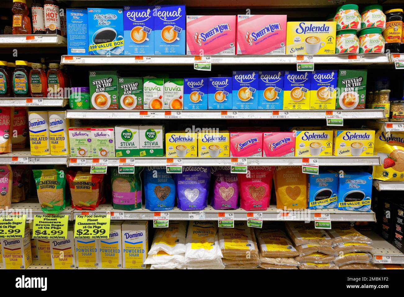 A variety of artificial sweeteners, and natural sweeteners including honey and sugar on an American supermarket grocery store shelf. Stock Photo