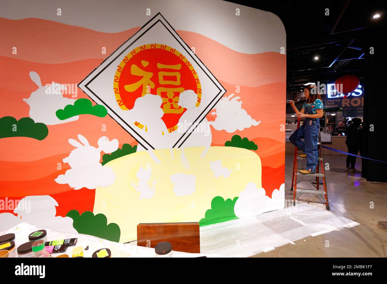 Artist Helen So works on a Lunar New Year painting at the Essex Market in New York City, January 16, 2023. The painting features ...(see more details) Stock Photo