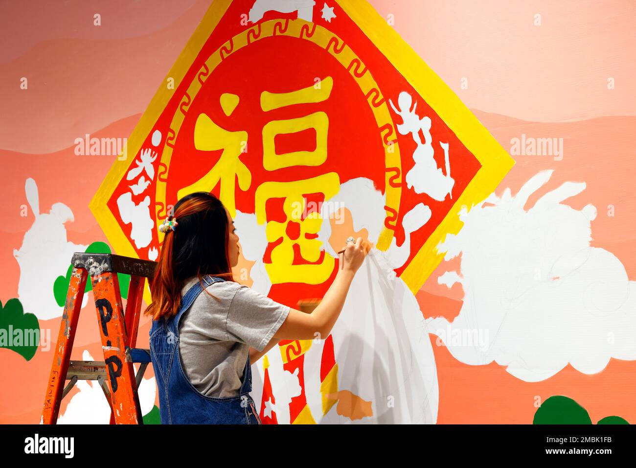Artist Helen So works on a Lunar New Year painting at the Essex Market in New York City, January 17, 2023. The painting features ...(see more details) Stock Photo